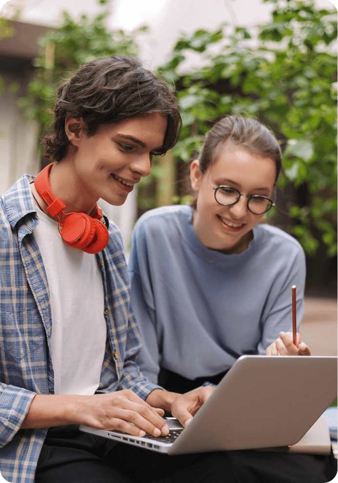 Two students working together on a laptop